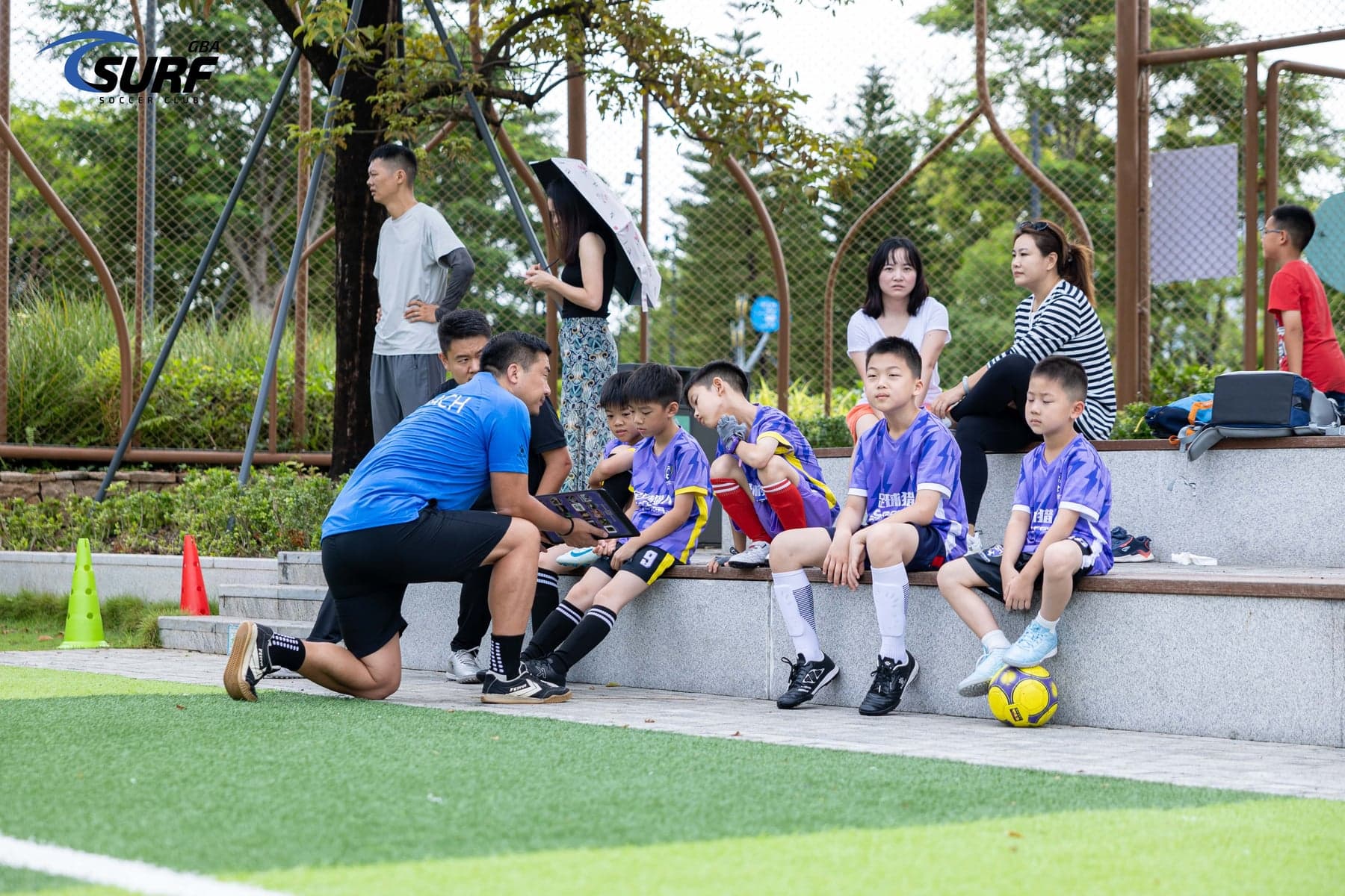 教练在场边为 SoccerRangers 球员讲解比赛